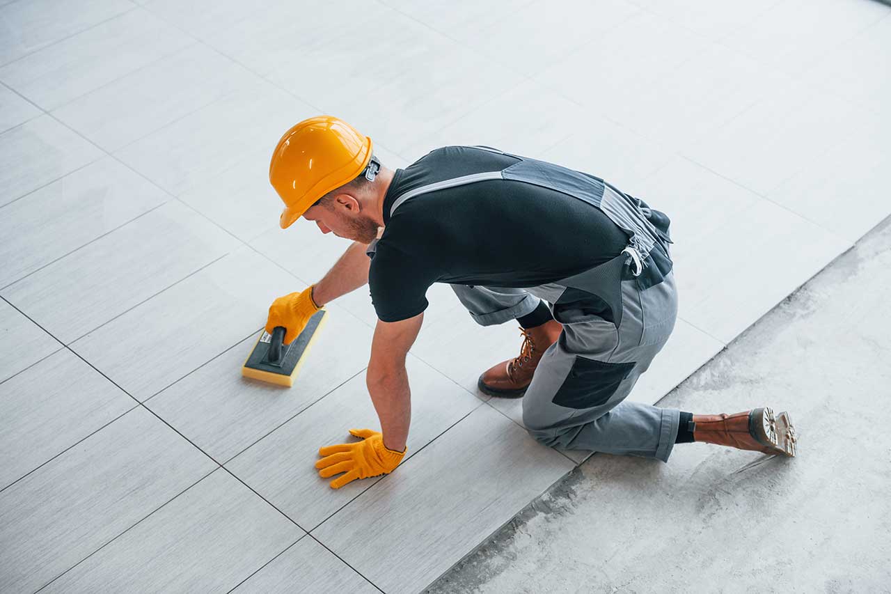 a worker setting tile flooring